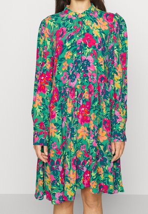 Blumenkleid mit grünem Grundton, gepunktet mit rosa, orangefarbenen und gelben Blumen, langen Ärmeln, rundem Kragen und einem lockeren, ausgestellt geschnittenen Design.