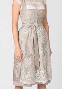 Beiges Spitzenkleid mit einem taillierten Oberteil, silbernen Knöpfen und einem Satinhüftband. Der Rock hat florale Stickerei und eine strukturierte Überlage.