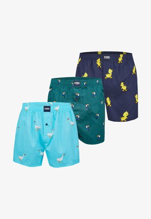 Tre par boksershorts i blå, blågrøn og marineblå med trykte hvide gæs, tukaner og gule ællinger.