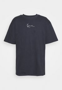 Camiseta de algodón de color azul oscuro con mangas cortas y cuello redondo, con un detalle de firma bordado en blanco en el pecho.