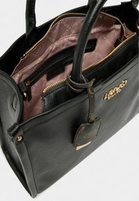 Sort læderhandtaske med dobbelt håndtag, en tekstureret overflade, og et pink stofinteriør med lynlåslommer og stiklommer. Guld hardware detaljer.