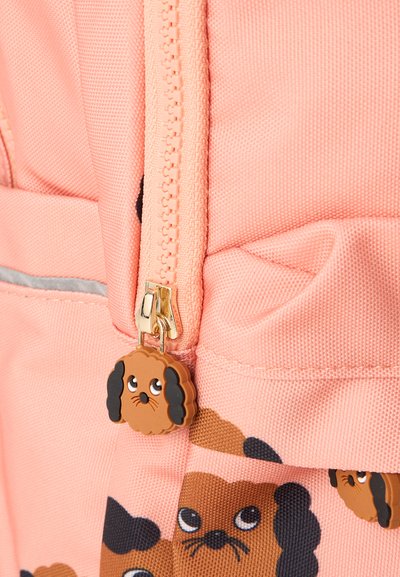 Mochila rosa con un cierre dorado y un tirador en forma de perro. La tela tiene un diseño texturizado adornado con pequeños patrones de perros.