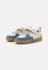 Guttas sneakers med en blå tøffel i semsket skinn, hvit lær, røde snøringer, borrelåsstropp, grønn hælakkent og gummisåle.