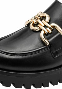Black leather loafer with a chunky black rubber sole, featuring a gold chain accent on the front. Smooth texture with stitching details.