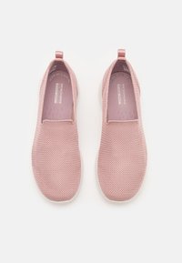 Zapatos de slip-on de color rosa claro con parte superior de malla, lados elásticos y plantilla acolchada. Suela plana de goma blanca con etiqueta de marca en el interior.