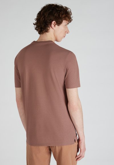 Krótki rękawek, brązowy t-shirt z miękkiego materiału o prostym kroju. Posiada boczne rozcięcia na końcu, zapewniające wygodę i swobodę ruchów.