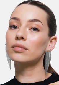 Zilveren kettingoorbellen met een lineaire staafstud, voorzien van cascade-fringe kettingen die naar beneden taps toelopen en zo een dramatisch, gestructureerd effect creëren.