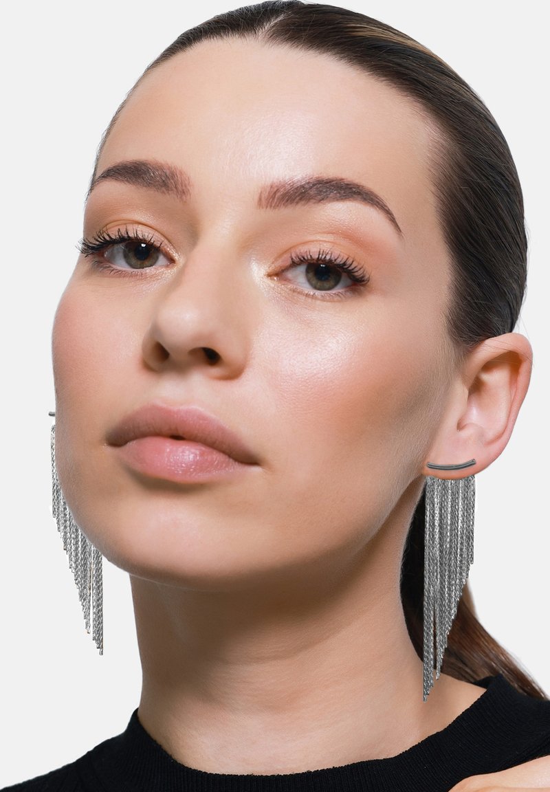 Zilveren kettingoorbellen met een lineaire staafstud, voorzien van cascade-fringe kettingen die naar beneden taps toelopen en zo een dramatisch, gestructureerd effect creëren.