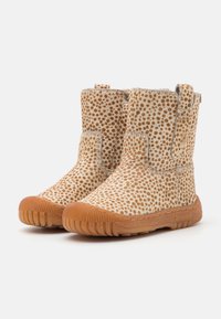 Bottines à motifs marron et crème, avec une texture douce, une semelle en caoutchouc et des coutures latérales, dotées de tirettes pour un enfilage facile.