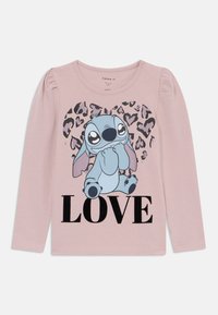 Gudras piedurknēm rozā krekls ar zilu multfilmu varoni, melnu tekstu "LOVE" un leopardu raksta fonu. Mīksta kokvilnas audums.