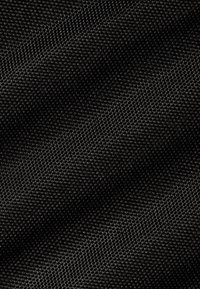Tissu noir texturé avec un motif tissé, comportant de petits points en relief pour une surface légèrement texturée. Convient à diverses applications.