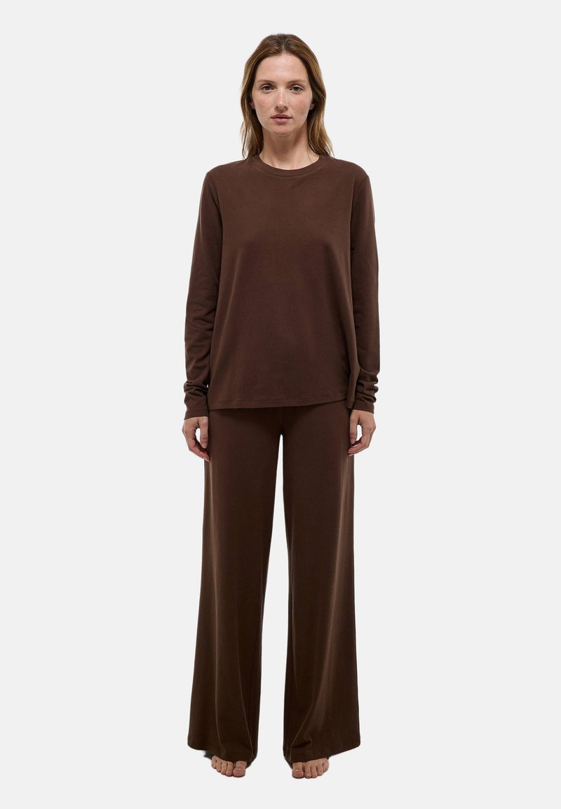 Haut à manches longues brun et pantalon large en tissu doux. La tenue présente une coupe décontractée avec des détails minimaux et sans motifs.