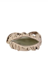 Beige lædertaske med en samlet design, lynlåslukning og en glat inderside. Har buede håndtag og synlige syninger.