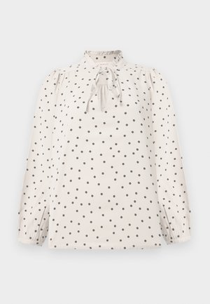 Blouse crème à pois noirs, manches longues bouffantes, col à volants froncés et détail de nœud à l'avant.