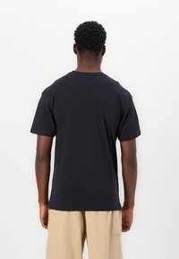 Black cotton T-shirt with short sleeves, a crew neckline, and a straight hem. Loose fit and soft texture, suitable for casual wear.