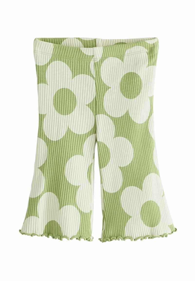 Shorts verts en tissu côtelé avec de grands motifs de fleurs de marguerite blanches et des bords festonnés.