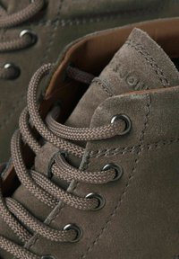 Stivali alla caviglia in suede grigio con lacci tondi, occhielli in metallo e superficie testurizzata. L'interno presenta una fodera in pelle liscia.