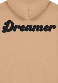Felpa beige realizzata in morbido tessuto, con una grande scritta ricamata in nero "Dreamer" sulla schiena e cappuccio a collo alto.