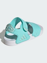 Turkusowe sandały z regulowanymi paskami, wykonane z pianki, z białą podeszwą. Wyposażone w teksturowane akcenty i detal z logo z trzema paskami.