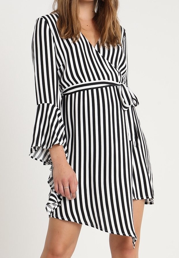 Gestreiftes Wickelkleid in Schwarz und Weiß. Hat weit ausgestellte Ärmel, einen Knoten in der Taille und einen asymmetrischen Saum. Leichter Stoff.
