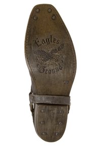 Brun lädersula med texturerad yta, prydd med en örn-grafik, varumärkesnamnet "Eagles" och flera metallspikar för grepp.