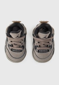 Beige Wildleder-Sneaker mit dunkelblauen Akzenten, gepolsterter Zunge und strukturierten schwarzen Mesh-Bereichen. Ausgestattet mit flachen Schnürsenkeln und Gummiaußensohle.