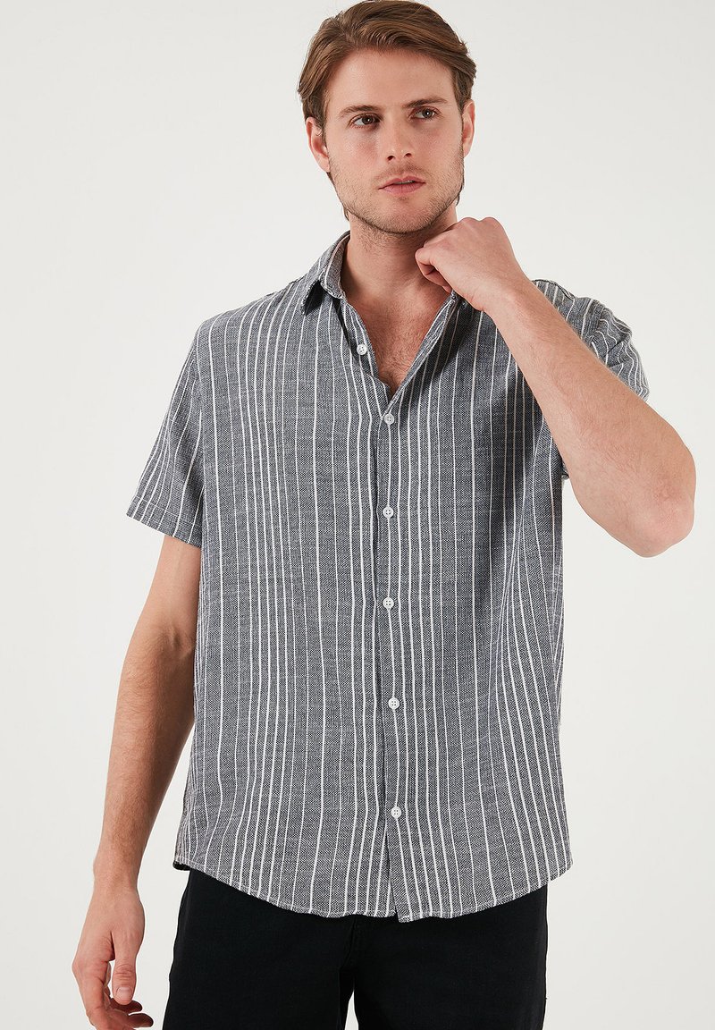 Korte mouwen, knoopshirt met een zwart-wit gestreept patroon, gemaakt van lichtgewicht stof met een zachte textuur en een relaxte pasvorm.