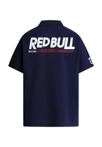 Marineblaues Poloshirt mit großem weißem "RED BULL"-Logo auf dem Rücken, roten Akzenten und dem Schriftzug "RACING" mit einem gestreiften Muster darunter.