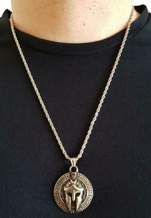 Collana in argento con un design intrecciato, caratterizzata da un pendente rotondo che raffigura un elmo circondato da un motivo a chiave greca.