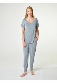 Sivý kompletný outfit na voľný čas s voľným krátkym rukávom a výstrihom do V, spolu s nohavicami so elastickým pásom. Mäkká látka, pohodlný strih, dve bočné vrecká.