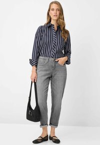 Marineblauw-wit gestreept shirt met kraag, grijze spijkerbroek, zwarte schoudertas en zwarte mesh ballerina's. Casual outfit met opgerolde mouwen.