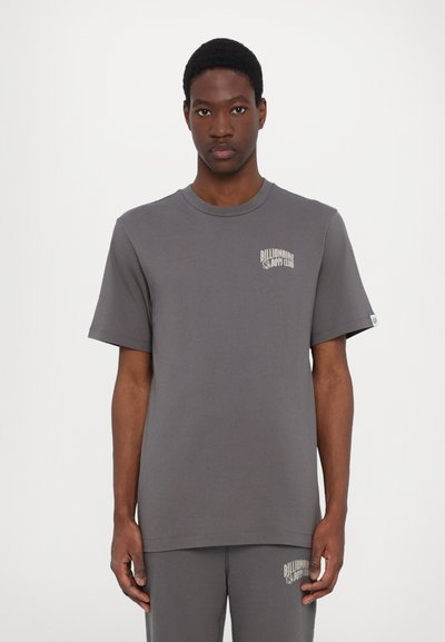 Grå bomuld t-shirt med korte ærmer, rund hals, med et lille beige logo på venstre bryst og en afslappet pasform.