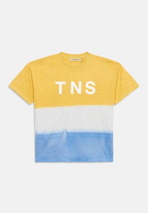 Pamučna majica kratkih rukava s žutim, bijelim i plavim vodoravnim blokovima boja i bijelim slovima "TNS" u sredini prsa.