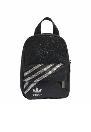 Musta Adidas minireppu, jossa on kimaltavat hopeiset kolme raitaa ja logo, yksi etutasku vetoketjulla ja yläpuolinen kantokahva.