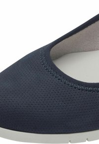 Zapato plano perforado de color azul marino con punta redonda, forro suave y suela de goma blanca en contraste. El borde presenta un detalle de costura.