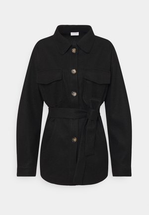 Zwarte jas met lange mouwen en kraag, vier knopen, twee borstzakken met kleppen en een strikceintuur in de taille.