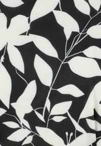 Tela negra con un patrón floral blanco que presenta hojas de diferentes formas y tamaños, con delgados tallos blancos que crean contraste y textura.