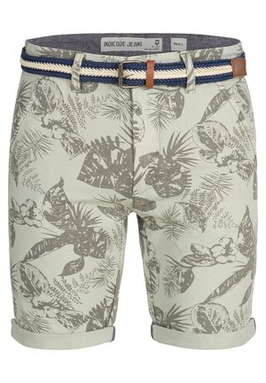 Pantalones cortos verde claro con un patrón floral texturizado en gris, con un dobladillo enrollado y un cinturón trenzado en azul marino y blanco con acentos de cuero marrón.