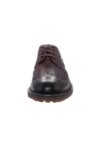 Chaussure habillée en cuir marron avec un laçage, dotée de détails en brogue sur le bout et d'un cap en cuir noir lisse. Semelle en caoutchouc plate.