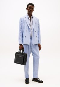Light blue linen double-breasted suit, striped shirt underneath, black leather briefcase, glossy black shoes. Simple and formal design.