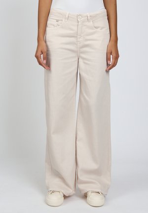 Helle beige weit geschnittene Hose aus weichem Stoff, mit vorderen Taschen, einem Knopfverschluss und kombiniert mit weißen Sneakers.
