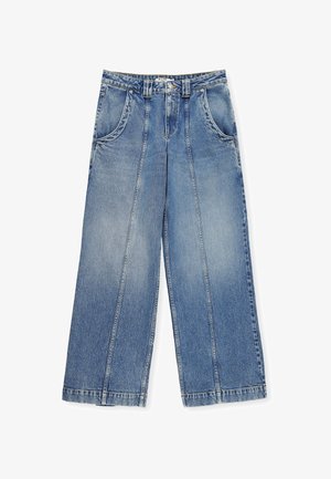 Breda ben blå denimbyxor har en ljus tvätt, fem fickor och tydlig sömnad. Tyget har en mjuk, strukturerad yta.