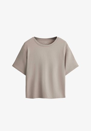 Rövid ujjú, bézs színű, rövidített pamut póló kerek nyakkivágással, fehér háttéren laposan elhelyezve.