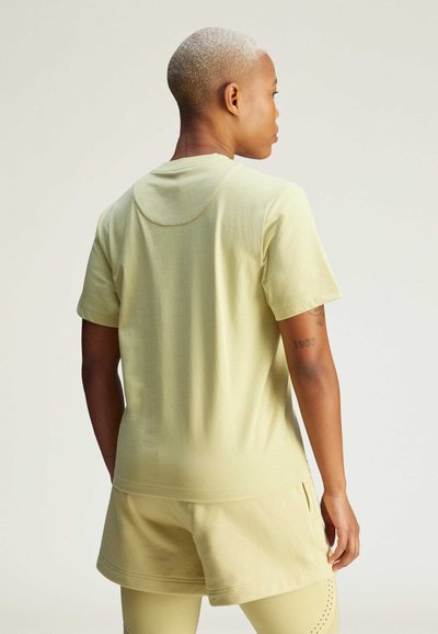 Chemise jaune clair à manches courtes avec un col arrondi, texture douce et coupe décontractée, associée à un short assorti dans une teinte similaire.