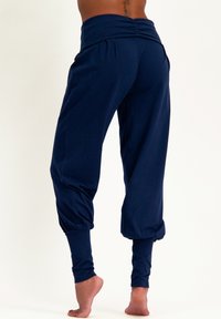 Navyblaue, locker sitzende Jogginghose aus weichem Stoff, mit einem breiten Bund, Raffungen an den Knöcheln und einem schmal zulaufenden Design.