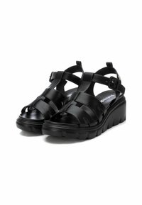 Sandalias de cuña negras con correas elásticas, diseño de puntera abierta, suela texturizada y correa ajustable en el tobillo. Color negro sólido en toda la sandalia.