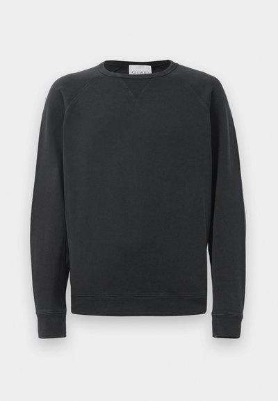 Melna garenā piedurknē krekla sporta krekls ar ribotām aprocēm un apakšmalu, smalka V-veida šuvju detaļa zem apkakles un preču zīmes etiķete kakla iekšpusē.