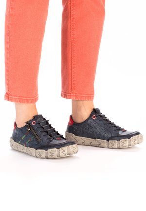 Baskets décontractées bleu marine en cuir texturé, avec des accents de couture colorés, des parties arrière rouges et une fermeture à glissière ; semelle en caoutchouc avec profil.