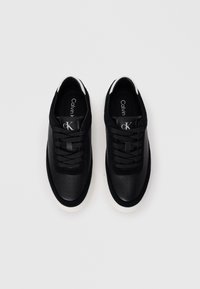 Sneakers neri con pannelli in pelle e scamosciato, lacci piatti e suola in gomma bianca. Presentano un design perforato e il logo sulla linguetta.