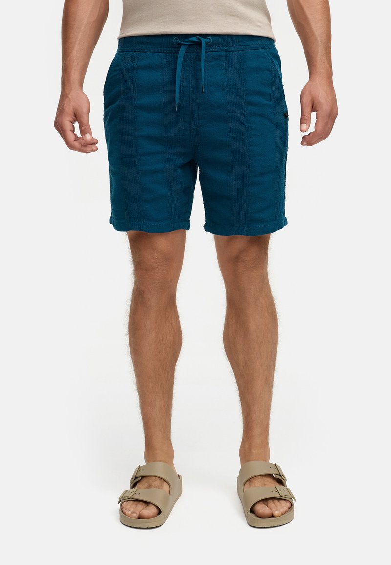 Tiefblaue Shorts aus strukturiertem Stoff, mit einem elastischen Bund mit Kordelzug und leicht umgeschlagenem Saum. Lässiger Schnitt.